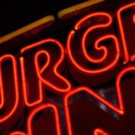 Photo of a neon sign with the letters U, R, G, E, representing the difficulty of urge suppression for the patient in recovery.