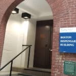 Photo of a stairwell and door marked BOSTON DISPENSARY BUILDING at the Tufts Medical Center illustrating a stop on the recovery trail.
