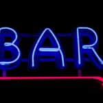 Photograph of a neon BAR sign with an arrow pointing indicating the temptation to relapse from alcohol use disorder.