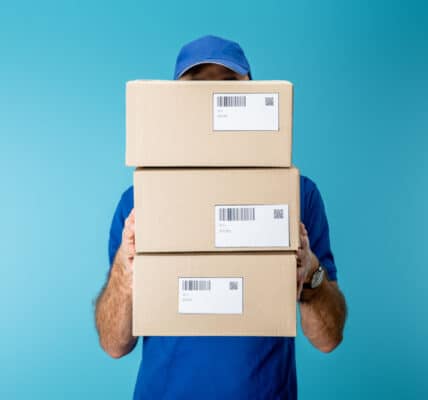 Photo of package delivery person holding three parcels in front of him which is symbolic of compulsive buying disorder.