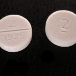 Photograph of the front side and back side of a Valium pill, a commonly-prescribed benzodiazepine.