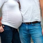 Pregnant women standing with her partner.