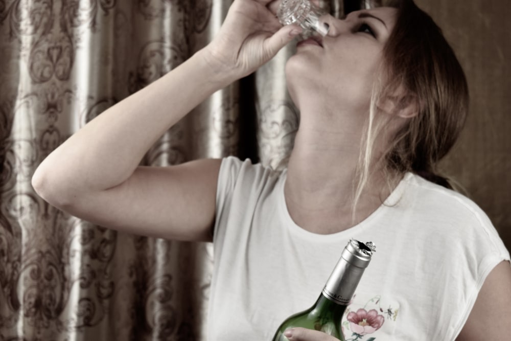 Photo of a woman portraying a sexual abuse survivor suffering from alcohol use disorder.