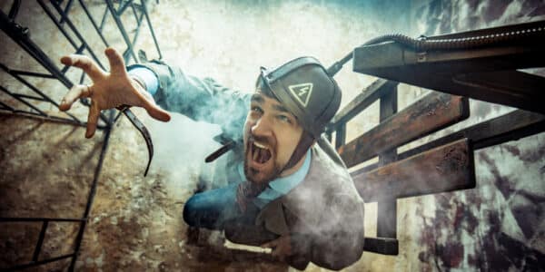 Photo of an actor in a suit in an electric chair showing the power of fantasizing about revenge.