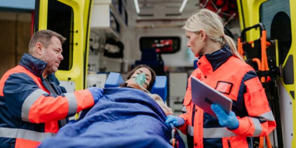 Photo of an overdose victim being loaded into an ambulance to be taken to the emergency room where she has a slim chance of being enrolled in an addiction treatment program.