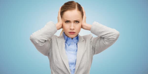 Photo of robotic-looking woman with her hands over her ears and an expression indicating cognitive dissonance.