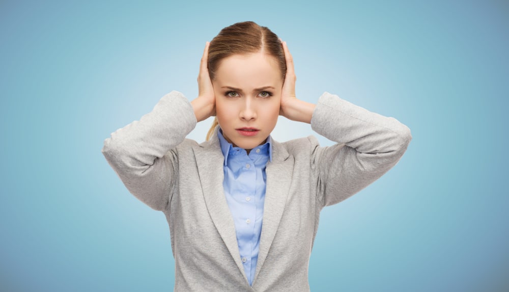 Photo of robotic-looking woman with her hands over her ears and an expression indicating cognitive dissonance.