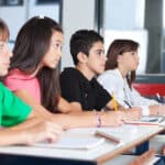 Photograph of teenage students at their desks in a classroom taking notes on a substance abuse prevention program.