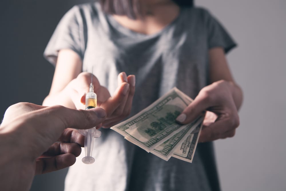 Photo of a woman exchanging a urine sample for payment as in a contingency management program.