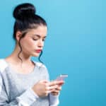 Photo of a young woman focused on her smartphone as a symbol of short video addiction.