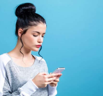 Photo of a young woman focused on her smartphone as a symbol of short video addiction.