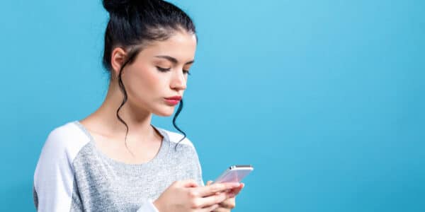 Photo of a young woman focused on her smartphone as a symbol of short video addiction.