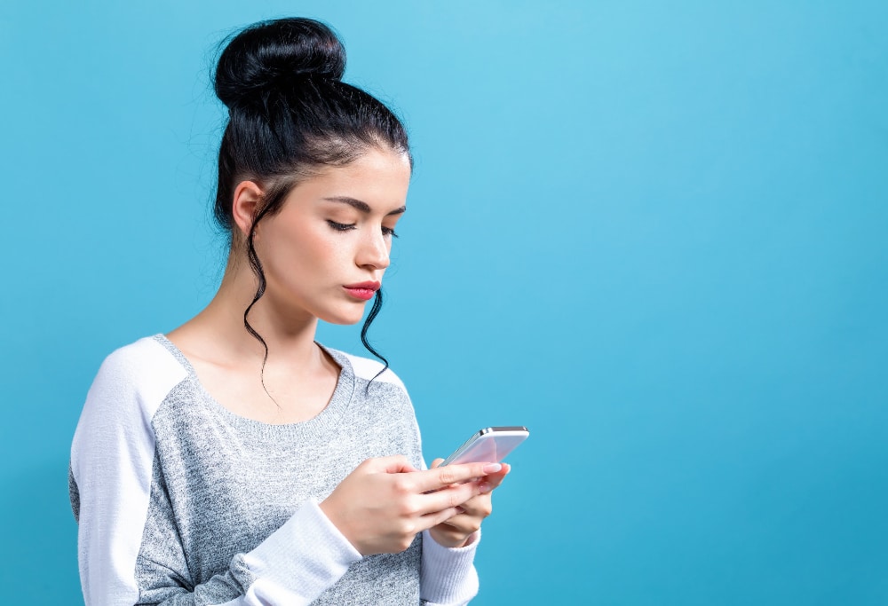 Photo of a young woman focused on her smartphone as a symbol of short video addiction.