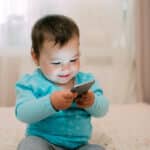 Photo of a child playing with a smartphone.