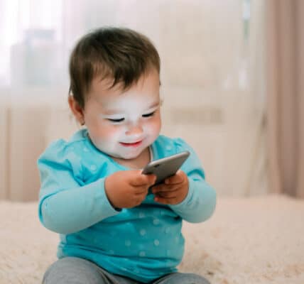 Photo of a child playing with a smartphone.