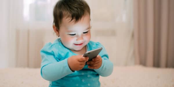 Photo of a child playing with a smartphone.