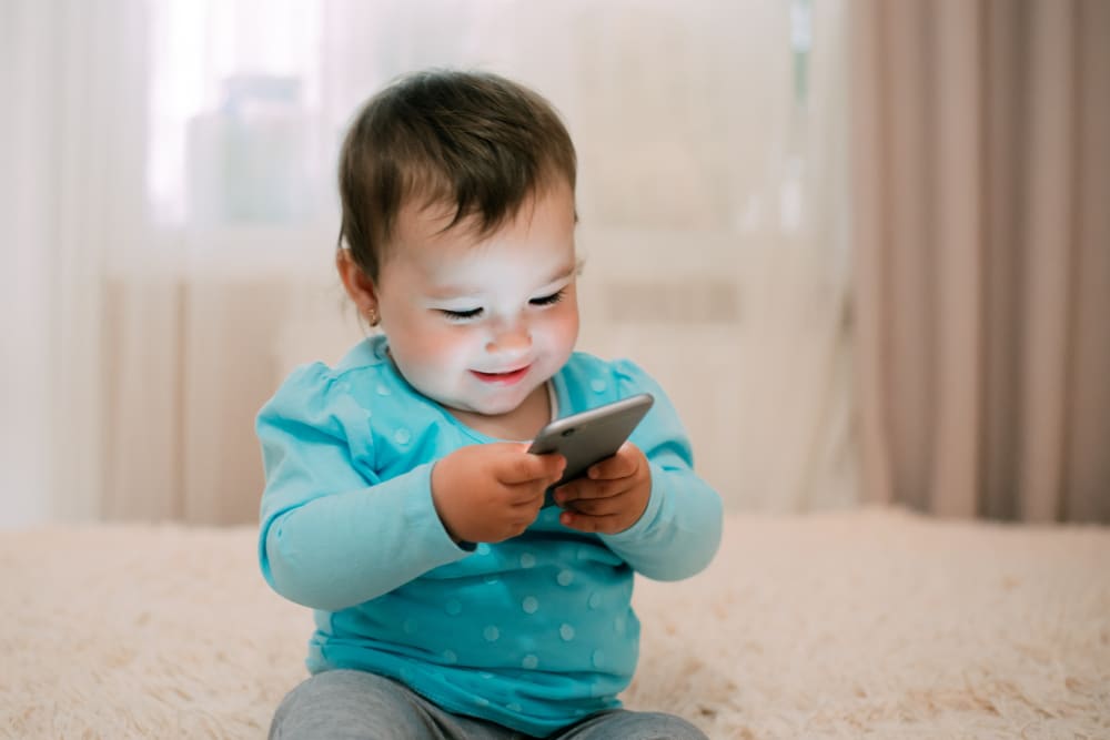 Photo of a child playing with a smartphone.