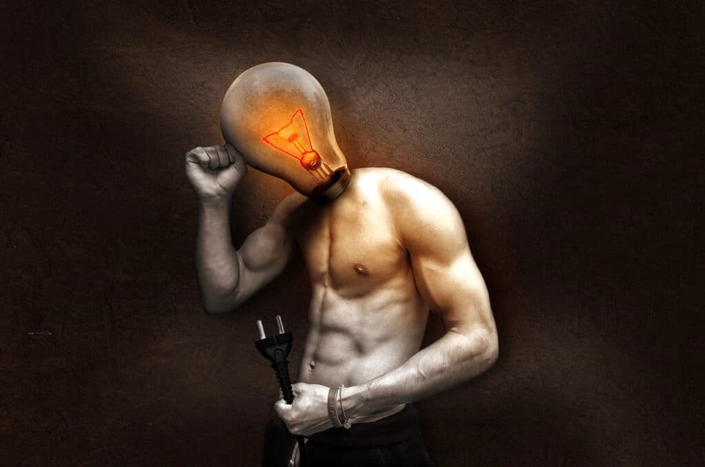 An image of a man with a light bulb for his head, pictured standing and holding a plug.