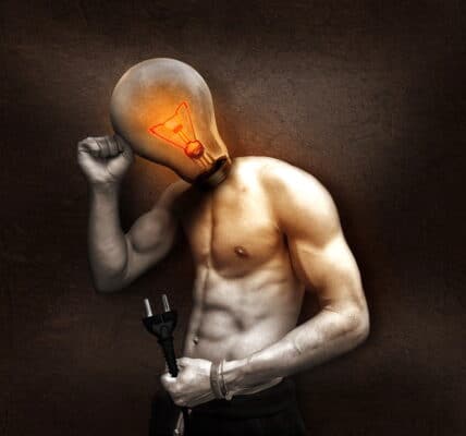 An image of a man with a light bulb for his head, pictured standing and holding a plug.