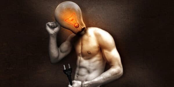 An image of a man with a light bulb for his head, pictured standing and holding a plug.