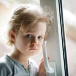 Photo of a child with an insecure expression typical of the children of addiction.
