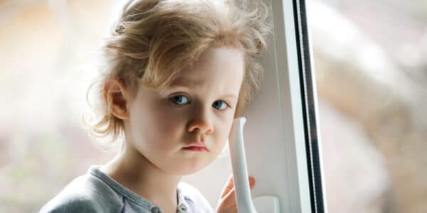 Photo of a child with an insecure expression typical of the children of addiction.