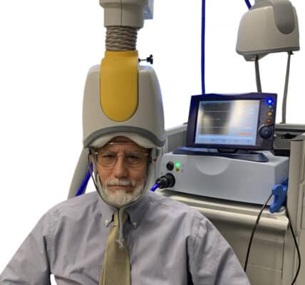 Photo of a researcher under a transcranial magnetic stimulation (TMS) cone.