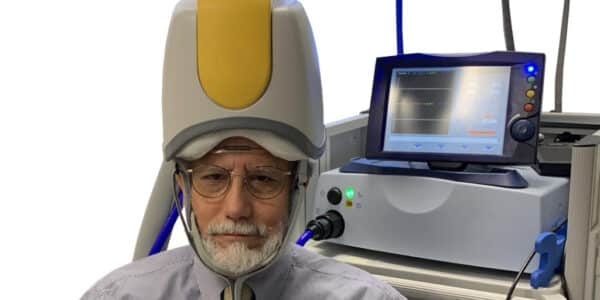Photo of a researcher under a transcranial magnetic stimulation (TMS) cone.