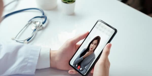 Photograph of a patient using an addiction recovery app to communicate with a medical professional.