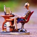 A skeleton sitting at the desk