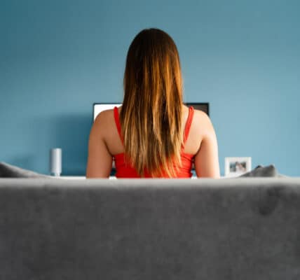 Photograph of a young woman sitting in front of a computer meant to indicate the compulsive use of pornography.