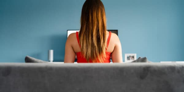 Photograph of a young woman sitting in front of a computer meant to indicate the compulsive use of pornography.