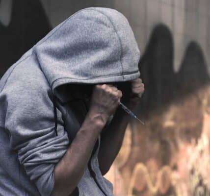 A young man in a hoodie, appearing to be in distress.