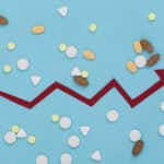 Image showing an economic growth chart amidst a background of pills symbolizing the growth of the addiction recovery economy.