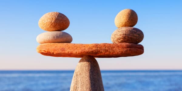 Photograph of stones perfectly balanced as a metaphor for transfer addiction and the need to find safe substitute activities to displace stress.