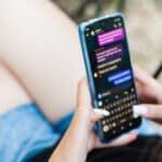 Photo of a young woman in dialogue with a AI chatbot.