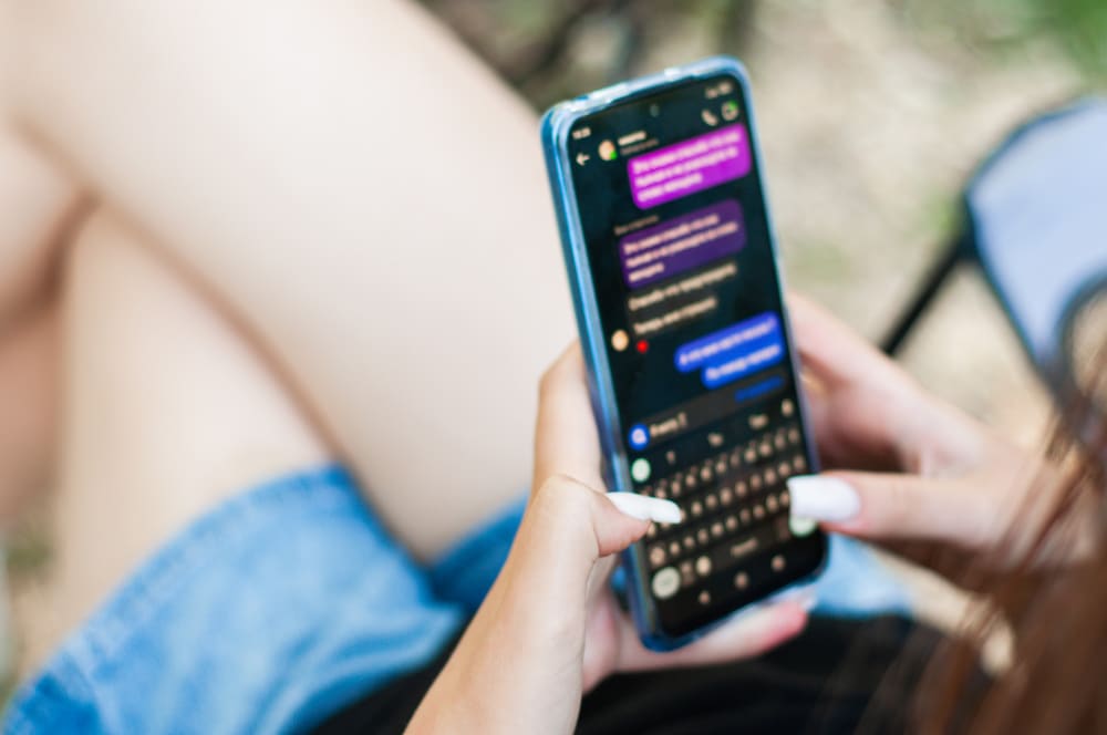 Photo of a young woman in dialogue with a AI chatbot.