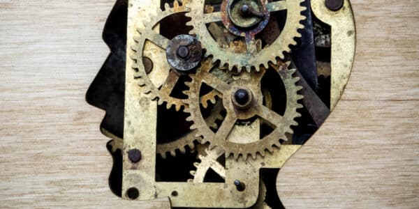 Illustration of a silhouette of the human head filled with gears, indicating the target of attentional bias modification.