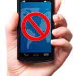 Photograph of a hand holding a smartphone and the screen displays the universal sign for "no" or "do not enter."