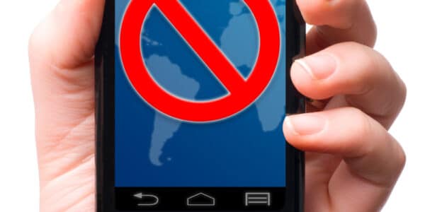 Photograph of a hand holding a smartphone and the screen displays the universal sign for "no" or "do not enter."