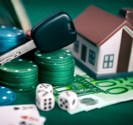 Photograph of a gambling problem, including playing cards, poker chips, and dice, and a care key and toy house representing losses.