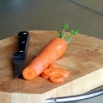 Photograph of a carrot and a knife on a cutting board.