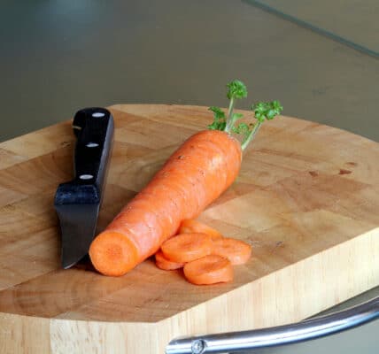 Photograph of a carrot and a knife on a cutting board.