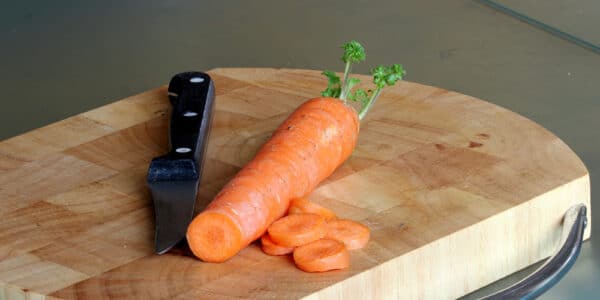 Photograph of a carrot and a knife on a cutting board.