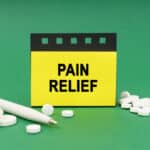 Graphic with a sign reading "PAIN RELIEF" surrounded by pills and a pen.