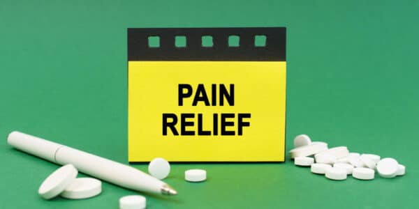 Graphic with a sign reading "PAIN RELIEF" surrounded by pills and a pen.