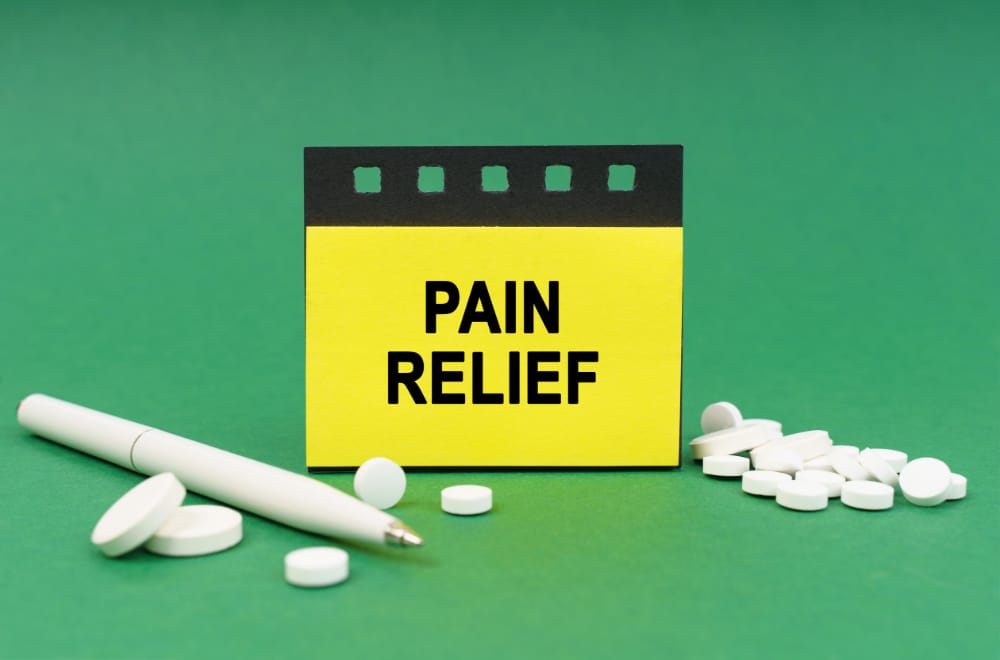 Graphic with a sign reading "PAIN RELIEF" surrounded by pills and a pen.