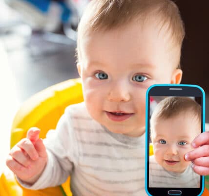Photo of a baby taking selfie with a smartphone camera.