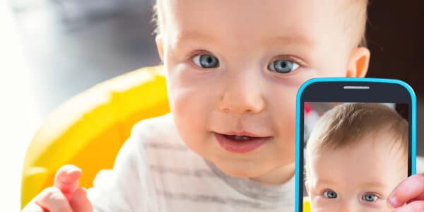Photo of a baby taking selfie with a smartphone camera.