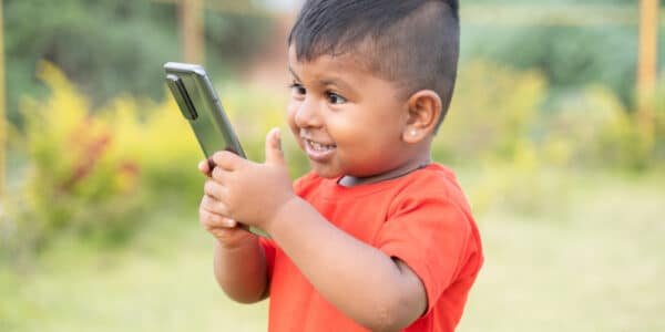 Photo of an excited child holding a smartphone.